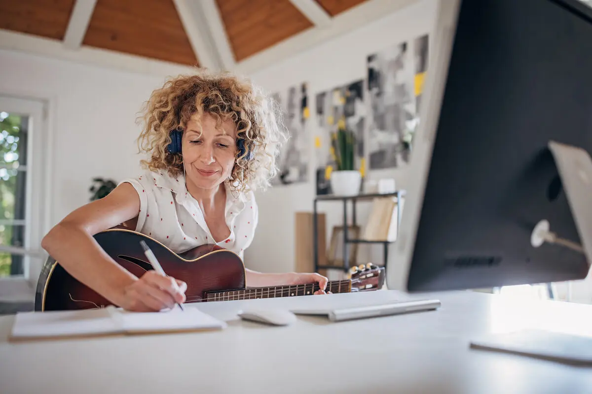 Woman writing music at a desk.