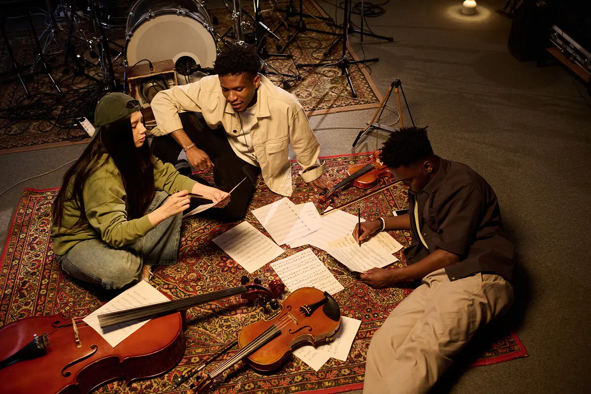Musicians collaborating on sheet music and instruments.