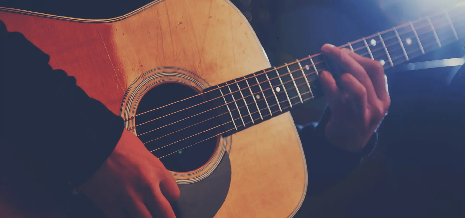 Person playing an acoustic guitar.